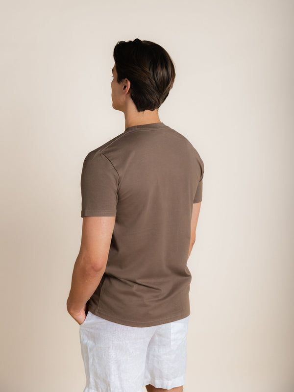 Achteraanzicht van het BERKN Signature T-shirt in Walnut, gedragen door Reno.